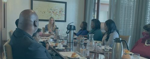 Kelly Loeffler sitting with black people eating croissants